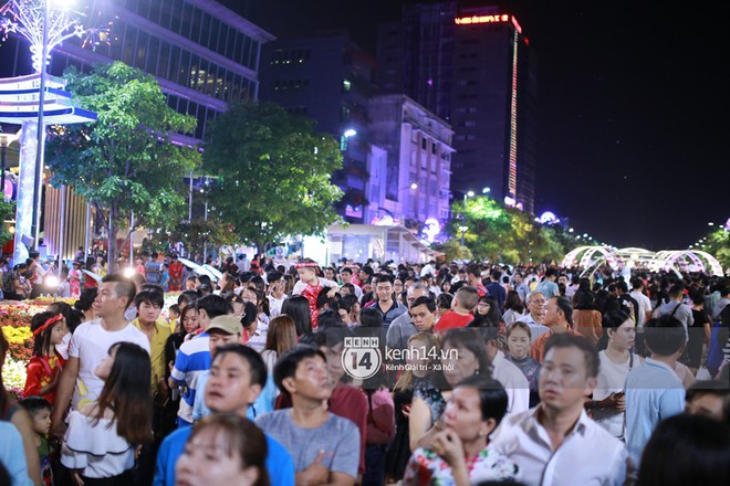 Sài Gòn tối mùng 1 Tết: Trẻ em thích thú cởi áo, nhảy vào đài phun nước đường hoa Nguyễn Huệ để nô đùa - Ảnh 2.