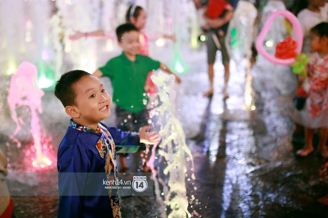 Sài Gòn tối mùng 1 Tết: Trẻ em thích thú cởi áo, nhảy vào đài phun nước đường hoa Nguyễn Huệ để nô đùa - Ảnh 10.