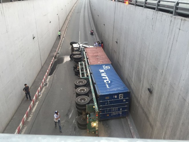 Container lật nh&agrave;o sau khi &ocirc;m cua trong hầm chui, t&agrave;i xế tho&aacute;t chết lồm cồm b&ograve; ra khỏi xe - Ảnh 1.