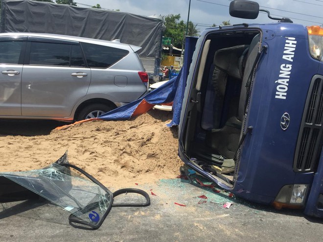 TP.HCM: Xe tải chở cát gây tai nạn rồi lật ngang giữa đại lộ Phạm Văn Đồng, tài xế bò ra khỏi cabin kêu cứu - Ảnh 1.