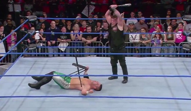 Kinh ho&agrave;ng đ&ocirc; vật WWE vỡ hốc mắt v&igrave; hứng trọn c&acirc;y gậy b&oacute;ng ch&agrave;y của đối thủ - Ảnh 2.