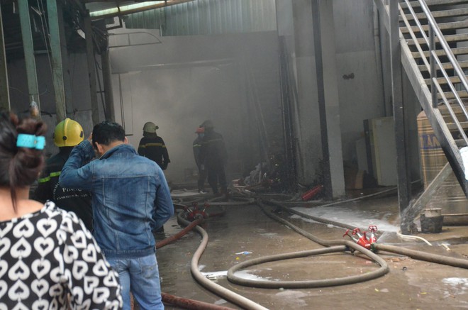 Cảnh sát PCCC phá tường dập lửa, công nhân bê đồ đạc tháo chạy khỏi công ty may mặc phát hỏa ở Sài Gòn - Ảnh 1.