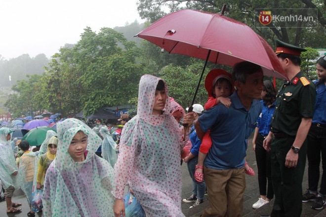 Hàng vạn người dân che ô đi khai hội Đền Hùng, lực lượng an ninh làm hàng rào sống đứng dưới mưa đảm bảo trật tự - Ảnh 10.