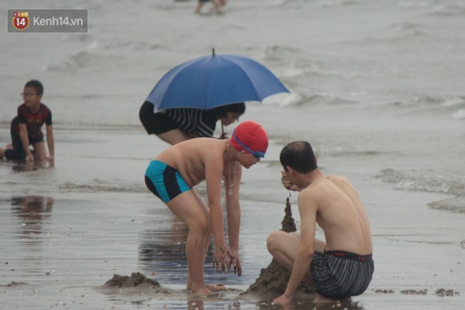 Trời vừa ngớt mưa, hàng nghìn du khách liền ùa xuống bãi biển Cửa Lò tắm mát - Ảnh 6.