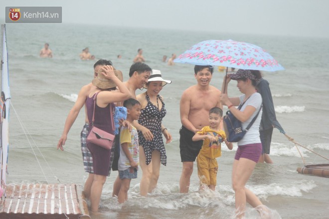 Trời vừa ngớt mưa, hàng nghìn du khách liền ùa xuống bãi biển Cửa Lò tắm mát - Ảnh 7.
