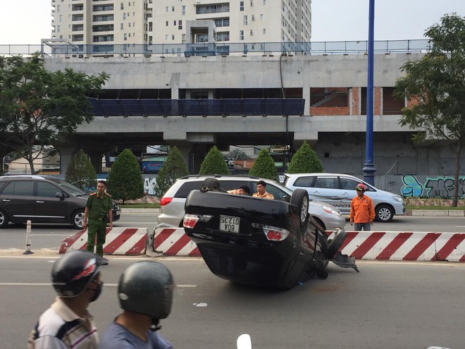 Xe ô tô đâm dải phân cách rồi lộn nhào, ngửa bụng trên đường phố Sài Gòn khiến nhiều người thót tim - Ảnh 2.