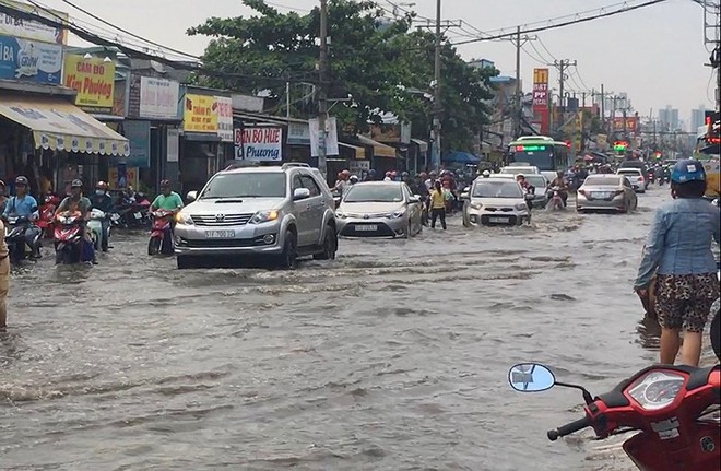 Xe chết máy, người dân bì bõm ở quốc lộ dù trời không mưa - Ảnh 1.