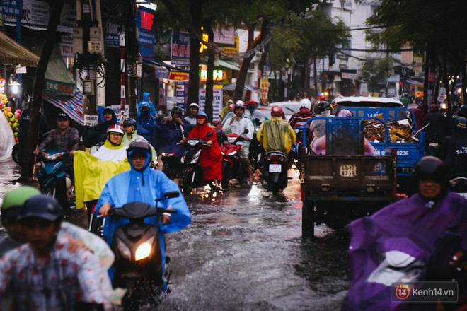 Phụ huynh ẵm bồng con nhỏ, bì bõm lội nước về nhà sau cơn mưa lớn ở Sài Gòn - Ảnh 18.
