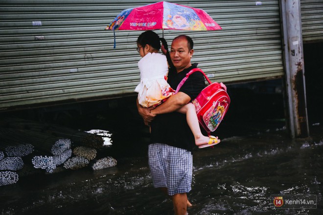 Phụ huynh ẵm bồng con nhỏ, bì bõm lội nước về nhà sau cơn mưa lớn ở Sài Gòn - Ảnh 15.