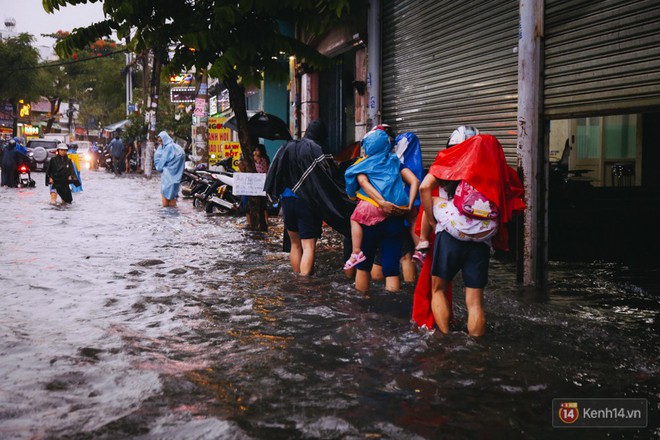 Phụ huynh ẵm bồng con nhỏ, bì bõm lội nước về nhà sau cơn mưa lớn ở Sài Gòn - Ảnh 12.