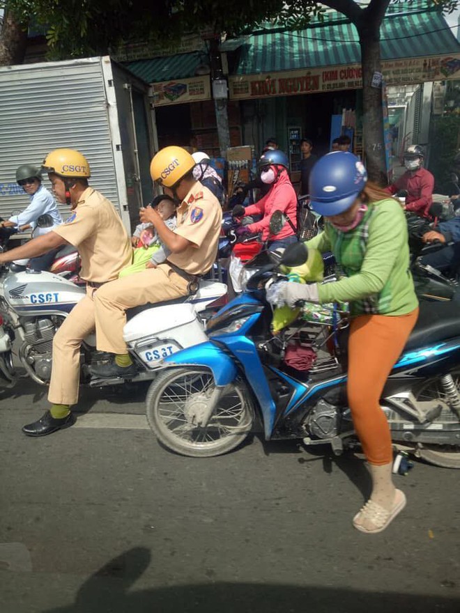 H&igrave;nh ảnh đẹp: 2 đồng ch&iacute; CSGT gi&uacute;p đỡ người phụ nữ, vừa cho b&uacute; b&igrave;nh vừa chở ch&aacute;u b&eacute; len lỏi qua đoạn đường &ugrave;n tắc đến bệnh viện kịp thời - Ảnh 2.