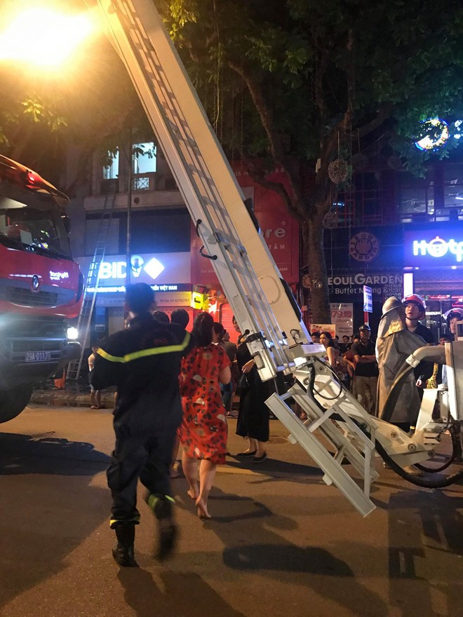 Cửa h&agrave;ng quần &aacute;o tr&ecirc;n phố H&agrave; Nội bốc ch&aacute;y, cả gia đ&igrave;nh được đưa xuống bằng xe thang - Ảnh 2.
