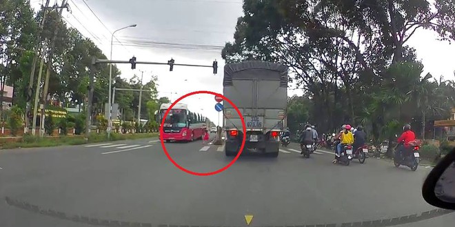 Clip: B&eacute; g&aacute;i chạy băng qua quốc lộ, su&yacute;t bị xe kh&aacute;ch c&aacute;n tr&uacute;ng khiến nhiều người thất kinh - Ảnh 2.