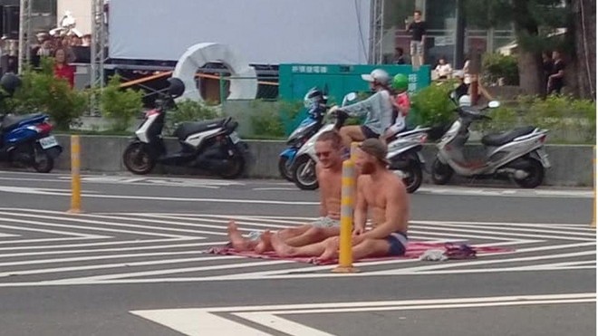 Tưởng nhầm đường phố Đài Loan là bãi biển, hai khách ngoại quốc hồn nhiên mặc quần đùi ngồi tắm nắng - Ảnh 1.