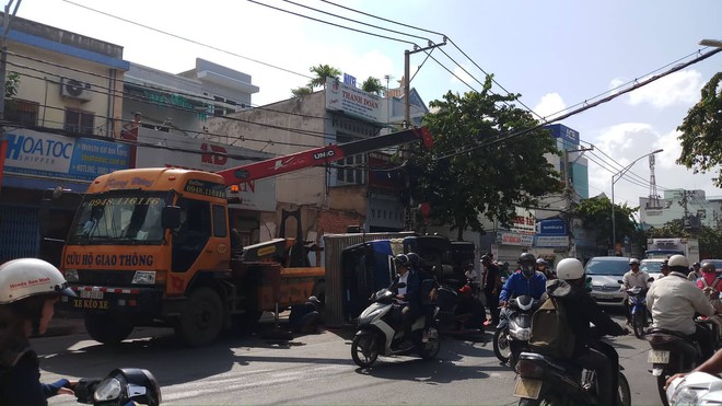 Xe tải lật nhào trên đường phố Sài Gòn, nhiều người đi đường thoát chết - Ảnh 2.