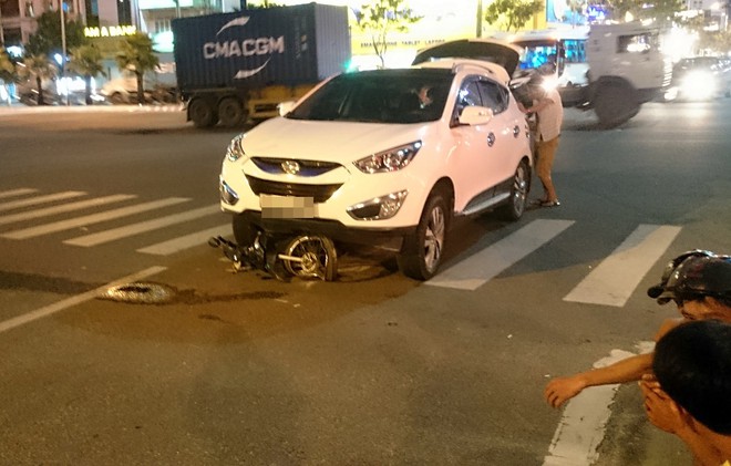 Xe máy nát bét dưới gầm ô tô, 2 thiếu nữ bị thương nặng - Ảnh 1.