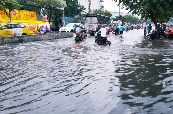 Người dân bì bõm lội nước đẩy xe về nhà vì nhiều tuyến đường ở Sài Gòn bị ngập nặng - Ảnh 2.