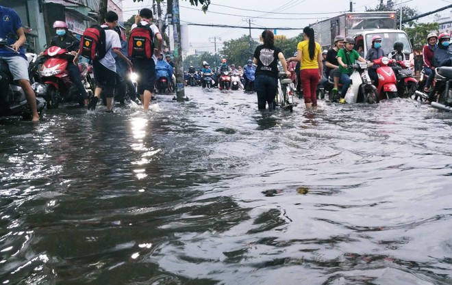 Người dân bì bõm lội nước đẩy xe về nhà vì nhiều tuyến đường ở Sài Gòn bị ngập nặng - Ảnh 7.