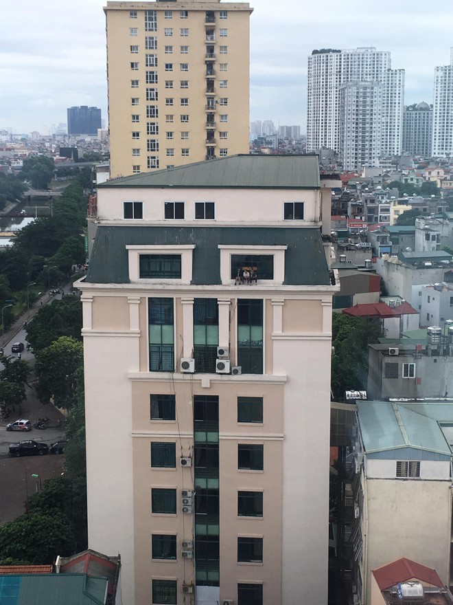 Hà Nội: Ba thanh niên ngồi vắt vẻo trên nóc nhà cao tầng tâm sự khiến cư dân mạng thót tim - Ảnh 1.