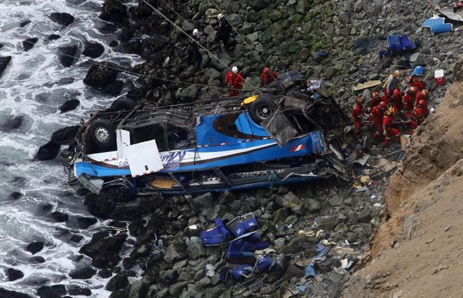 Ảnh: Gian nan cứu hộ chiếc xe bus lao xuống vực sâu cạnh biển ở Peru - Ảnh 1.