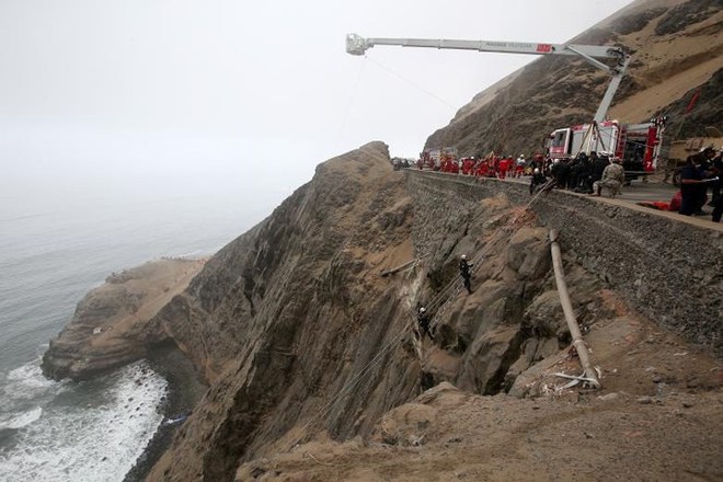 Ảnh: Gian nan cứu hộ chiếc xe bus lao xuống vực sâu cạnh biển ở Peru - Ảnh 2.
