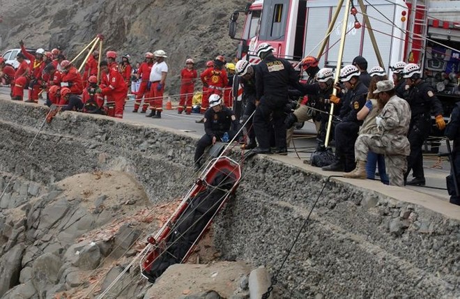 Ảnh: Gian nan cứu hộ chiếc xe bus lao xuống vực sâu cạnh biển ở Peru - Ảnh 3.