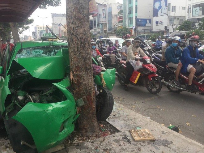 Sau va chạm trên đường, xe taxi tông mạnh vào gốc cây xanh ở Sài Gòn khiến 2 người nhập viện cấp cứu - Ảnh 1.