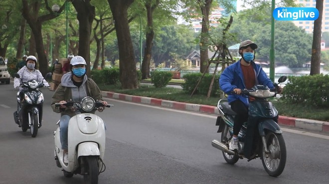 Hà Nội chính thức đón đợt gió lạnh đầu mùa, người dân mặc áo ấm xuống đường trong tiết trời se lạnh - Ảnh 2.