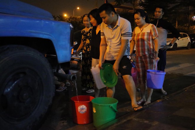 Ảnh: Người dân ở nhiều khu đô thị Hà Nội thức trắng đêm, xếp hàng chờ nhận từng xô nước sạch - Ảnh 16.