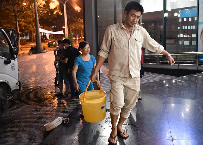 Ảnh: Người dân ở nhiều khu đô thị Hà Nội thức trắng đêm, xếp hàng chờ nhận từng xô nước sạch - Ảnh 9.