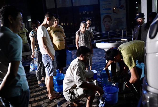 Ảnh: Người dân ở nhiều khu đô thị Hà Nội thức trắng đêm, xếp hàng chờ nhận từng xô nước sạch - Ảnh 14.
