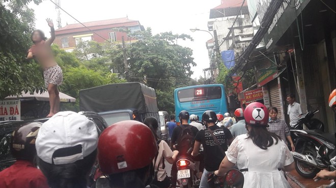 Hà Nội: Cô gái nghi ngáo đá cởi áo nhảy múa trên nóc xe ô tô khiến cả tuyến phố ùn tắc - Ảnh 1.