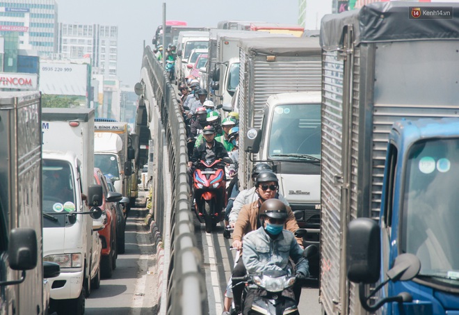 Chùm ảnh: Cửa ngõ sân bay Tân Sơn Nhất liên tục kẹt xe bất thường, ô tô dàn 2 hàng ép xe máy trên cầu vượt - Ảnh 2.
