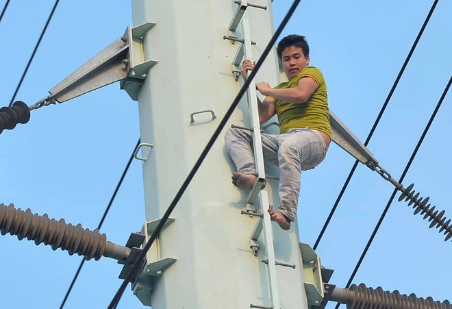 Hà Nội: Nam thanh niên trèo lên cột điện cao thế, tự trèo xuống sau 2 tiếng cố thủ - Ảnh 1.