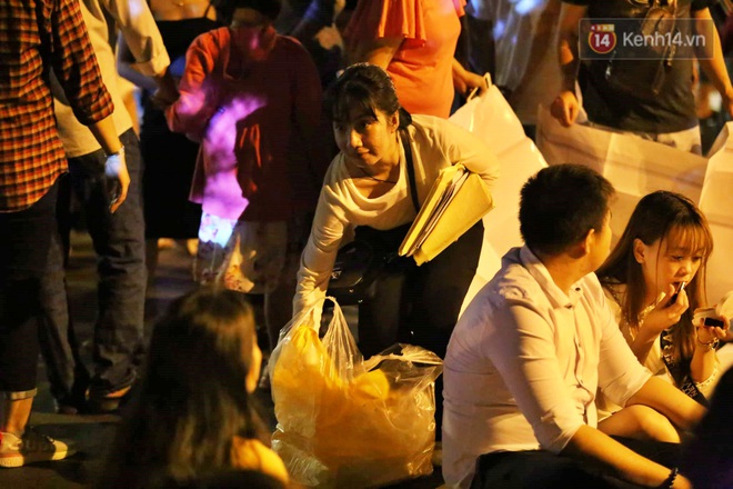Hàng vạn người đổ về trung tâm chờ xem pháo hoa, các thánh tranh thủ ở Sài Gòn ăn nên làm ra nhờ bán giấy lót ngồi - Ảnh 1.