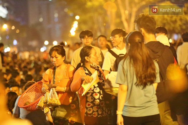 Hàng vạn người đổ về trung tâm chờ xem pháo hoa, các thánh tranh thủ ở Sài Gòn ăn nên làm ra nhờ bán giấy lót ngồi - Ảnh 2.