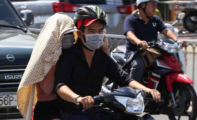Nắng nóng liên tục nhiều ngày ở Sài Gòn, người dân tìm cách bảo vệ da khỏi tia UV gần chạm ngưỡng khi ra đường - Ảnh 8.