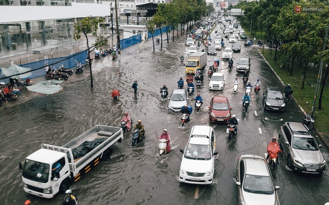 Mùa nóng chưa qua mùa ngập đã tới: Người Sài Gòn lại bì bõm lội nước về nhà sau cơn mưa lớn - Ảnh 2.