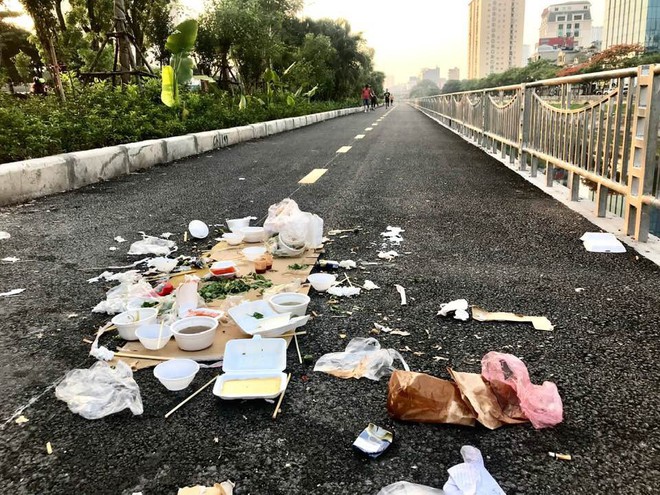 Đống bát đũa xốp, túi nilon cùng đồ ăn thừa bị bỏ lại trên đường đi bộ ven bờ sông Tô Lịch khiến nhiều người phẫn nộ - Ảnh 1.