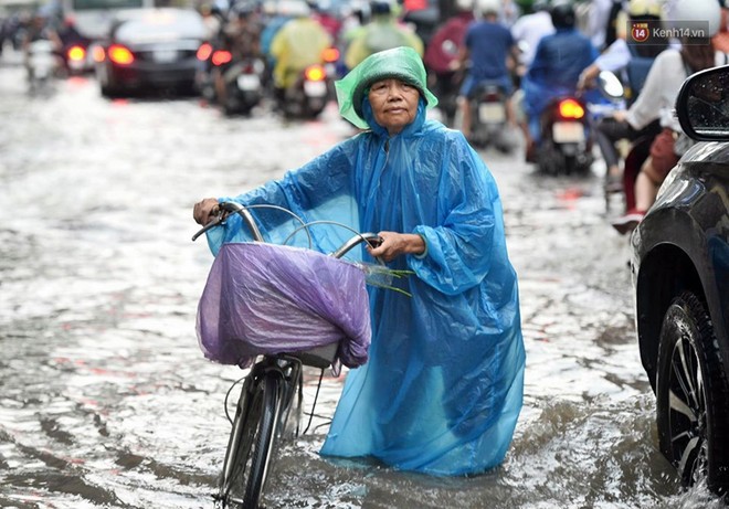 Người dân ngã sóng soài giữa dòng nước ngập trên đường phố Hà Nội sau cơn mưa - Ảnh 13.