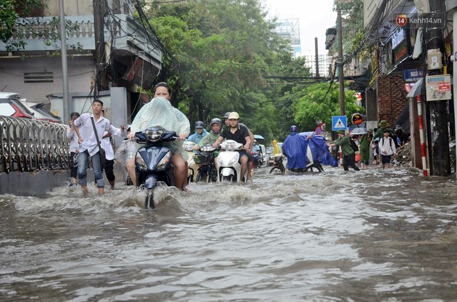 Người dân ngã sóng soài giữa dòng nước ngập trên đường phố Hà Nội sau cơn mưa - Ảnh 10.