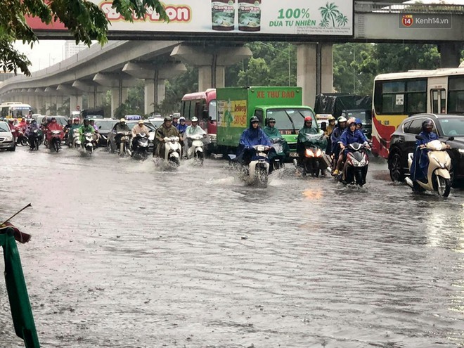 Người dân ngã sóng soài giữa dòng nước ngập trên đường phố Hà Nội sau cơn mưa - Ảnh 6.