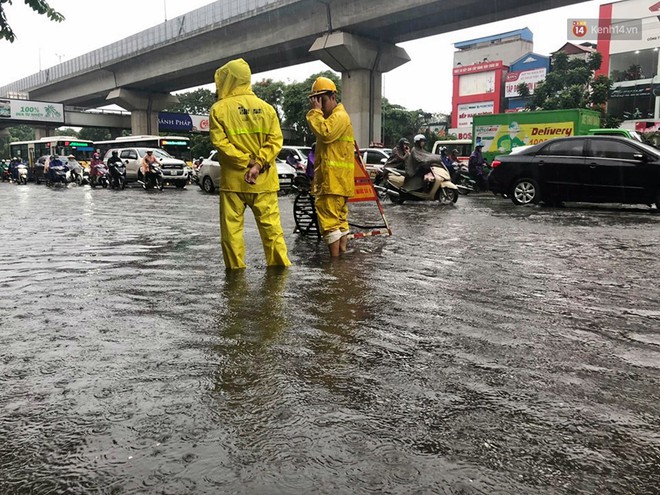 Người dân ngã sóng soài giữa dòng nước ngập trên đường phố Hà Nội sau cơn mưa - Ảnh 7.