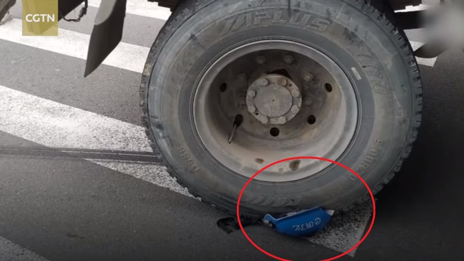 Bị xe tải c&aacute;n qua đầu, shipper sống s&oacute;t kỳ diệu nhờ đội mũ bảo hiểm xịn - Ảnh 2.