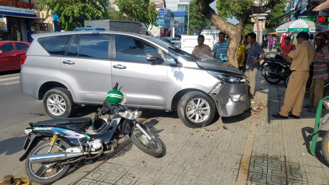 Ô tô nổ lốp, lao sang đường ngược chiều tông văng tài xế GrabBike ở Sài Gòn - Ảnh 1.