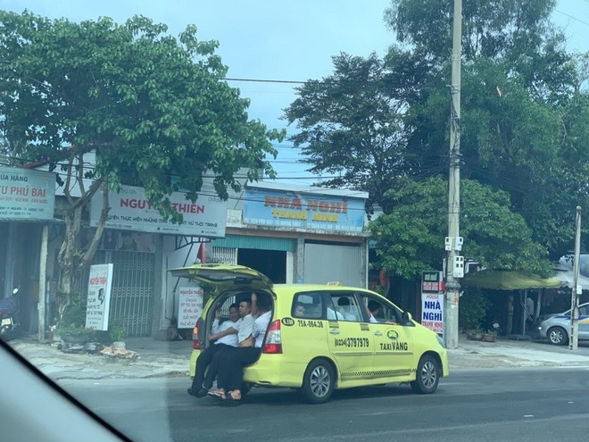 Taxi 7 chỗ “nhồi” 11 người, 3 người ngồi cốp xe như làm xiếc - Ảnh 1.