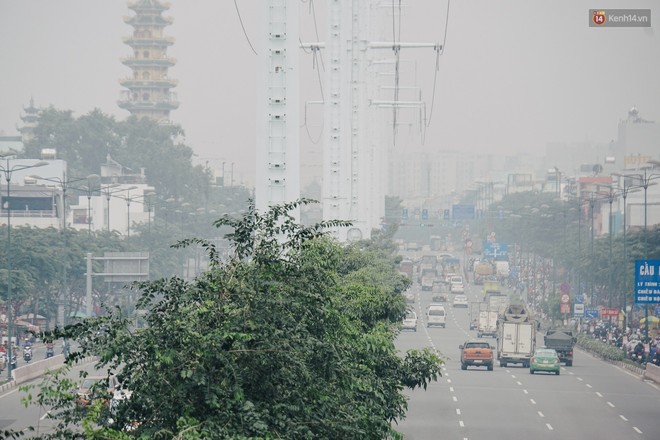 Ảnh: Sài Gòn bị bao phủ một màu trắng đục từ sáng đến trưa, người dân cay mắt khi đi ngoài trời - Ảnh 6.