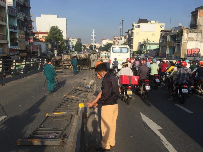 TP. HCM: Xe tải t&ocirc;ng văng dải ph&acirc;n c&aacute;ch rồi lao v&agrave;o th&agrave;nh cầu, c&ocirc; g&aacute;i bị mắc kẹt g&agrave;o kh&oacute;c k&ecirc;u cứu  - Ảnh 1.