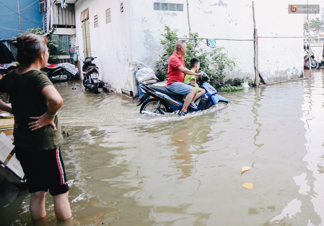 Ảnh: Triều cường gần đạt đỉnh gây ngập cả khu phố Sài Gòn, có gia đình vừa đứng vừa ăn cơm, có nhà ngập gần tới nóc - Ảnh 12.