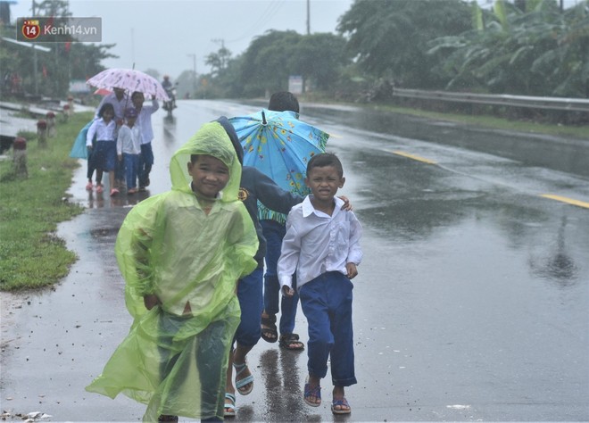 Không biết hoãn khai giảng, nhiều học sinh vùng lũ Quảng Trị đội mưa đi bộ đến trường - Ảnh 1.